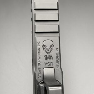 Close-up of a pistol slide with a skull engraving and the text '1/5 USA' and 'Shelburne, VT' along the side.